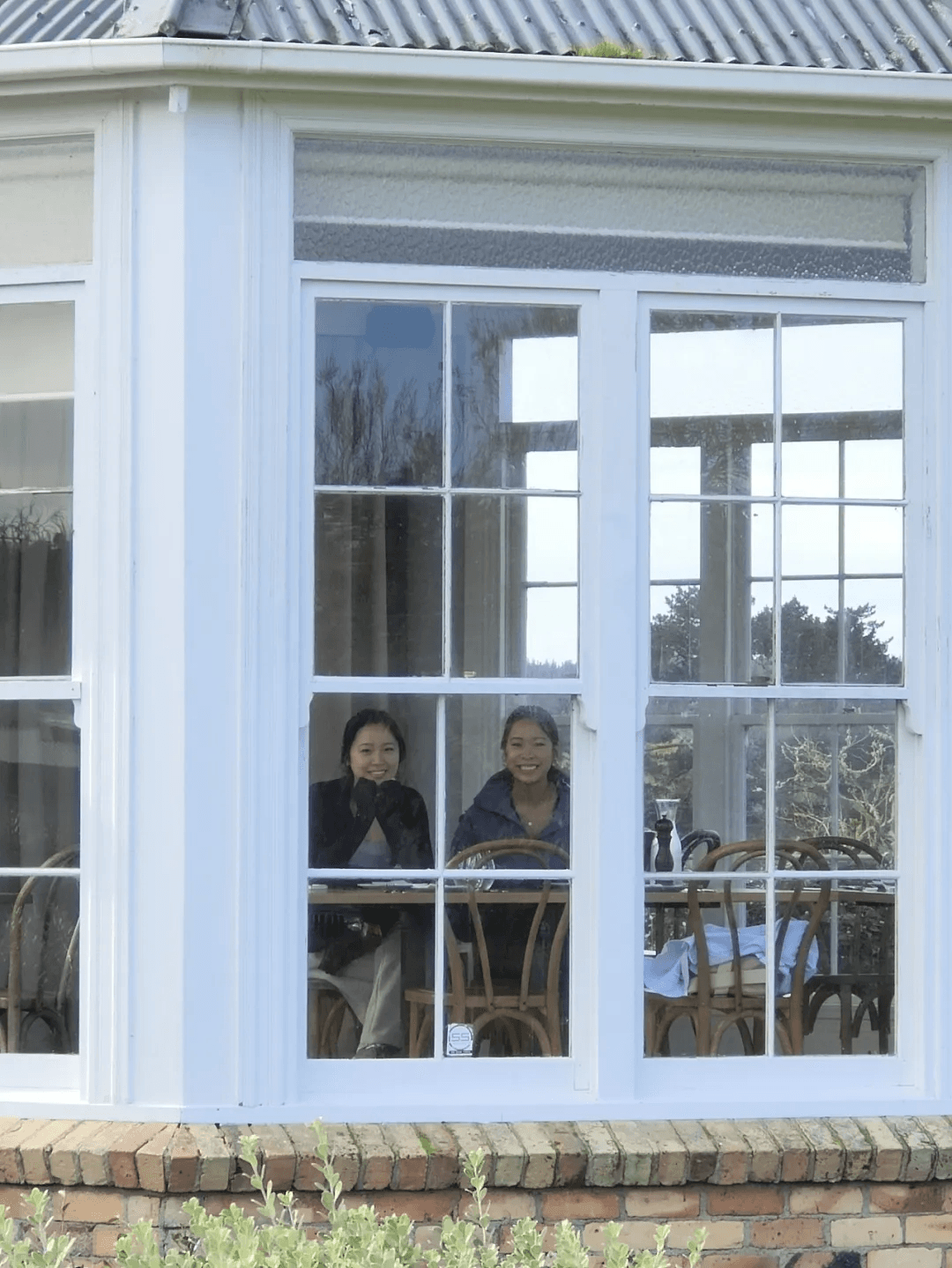 Ella and Ally sitting behind the window