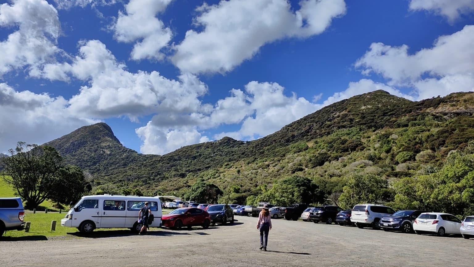 A car park at Whatipū Road with steep hills in the background